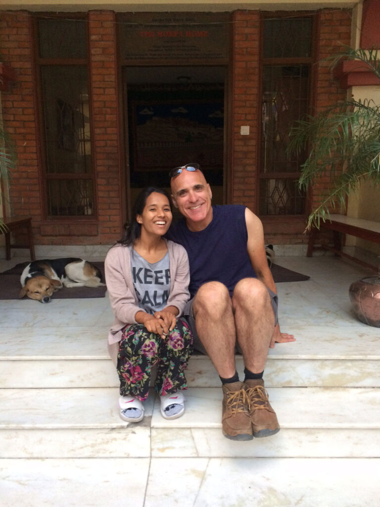 Inner Space host, Ralph Williams, sits next to his female friend, Anju, on the stone steps in front of the ROKPA Children's Home in Kathmandu, Nepal.