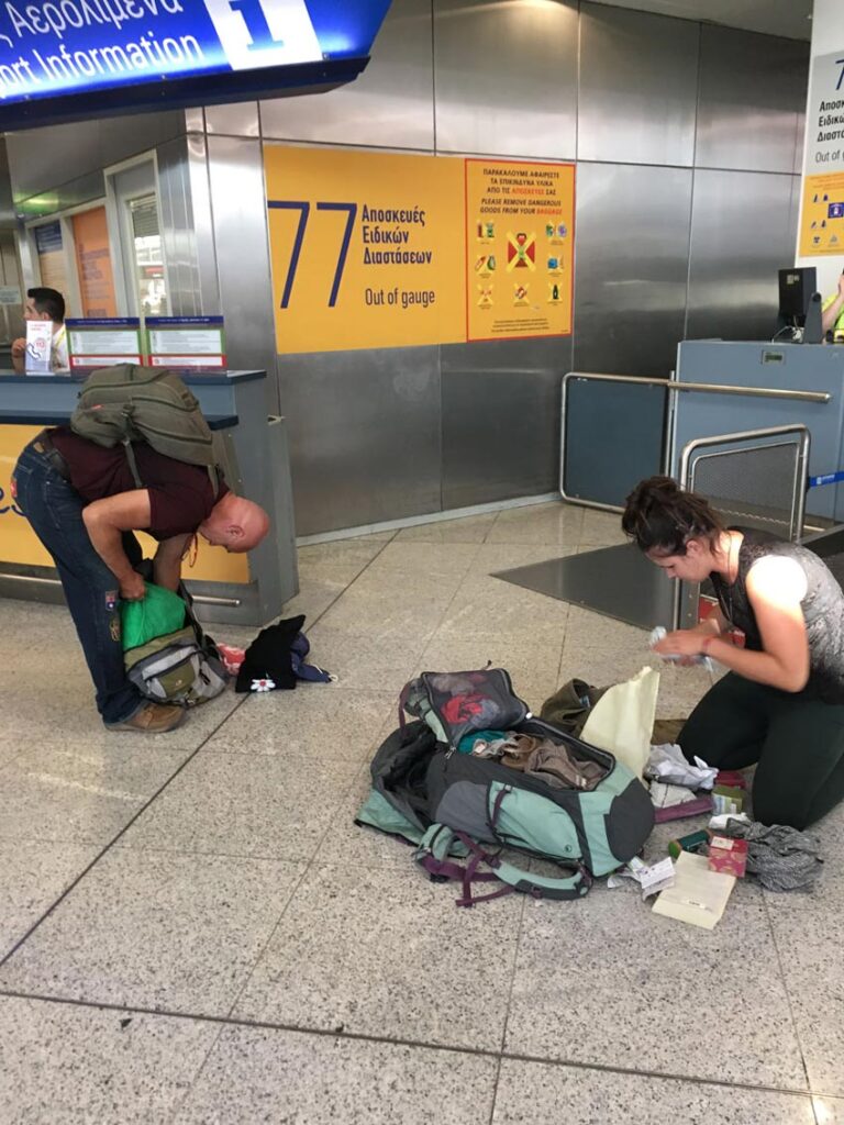 Inner Space host, Ralph Williams, and his daughter repack their luggage on the ground at the Athens airport.