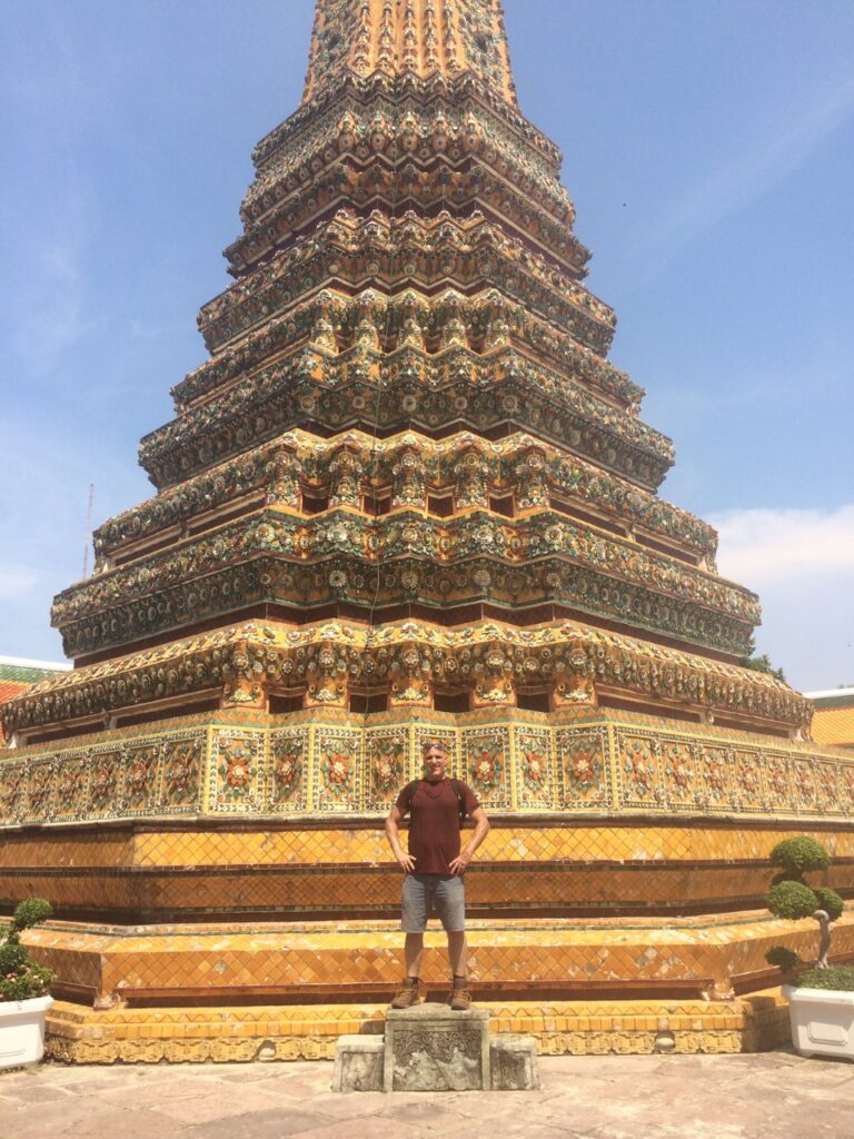 Inner Space host, Ralph Williams, stands on a pedestal in front of a colorful and intricate pagoda.