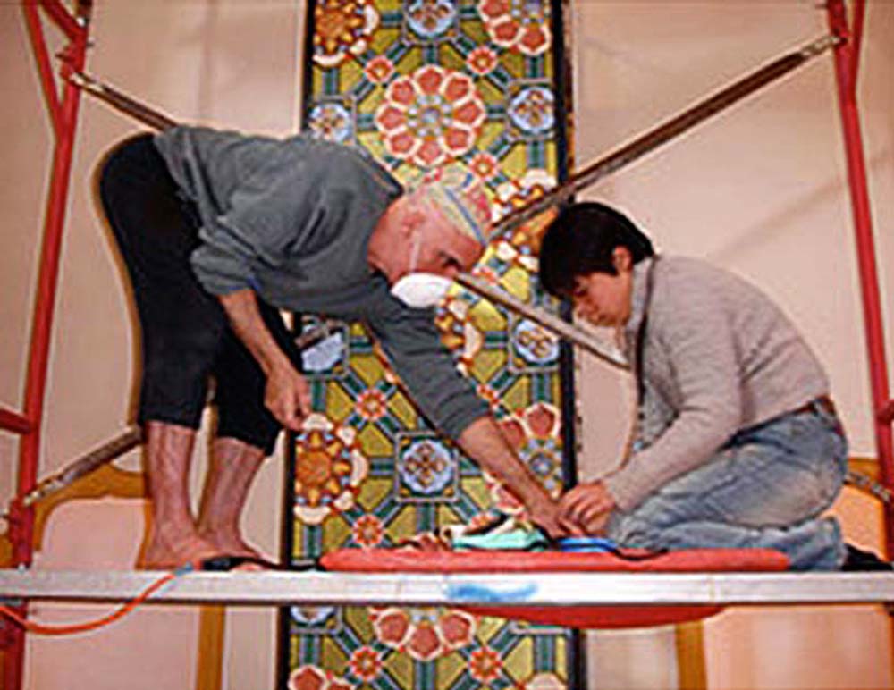 Ralph Williams works with fellow artist, Yuki, on scaffolding to put finishing touches on an ornate column inside The Great Stupa of Dharmakaya in Colorado.