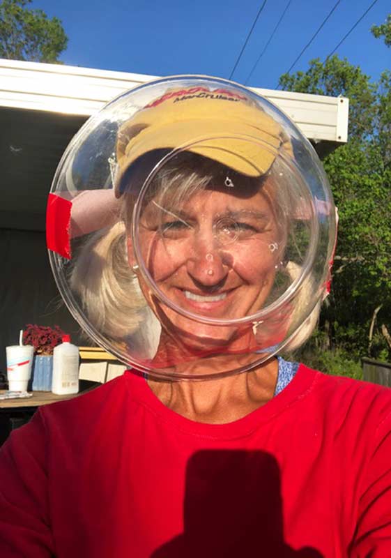 Selfie of Dana Brock with her head in a plastic fish bowl.