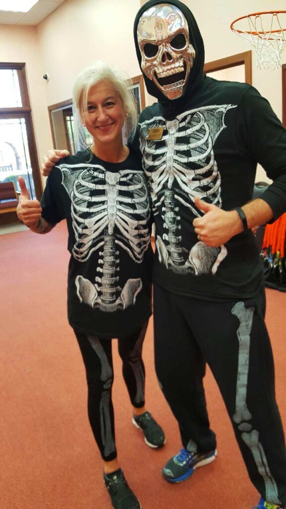 Dana Brock and her male supervisor stand side-by-side in matching skeleton costumes.