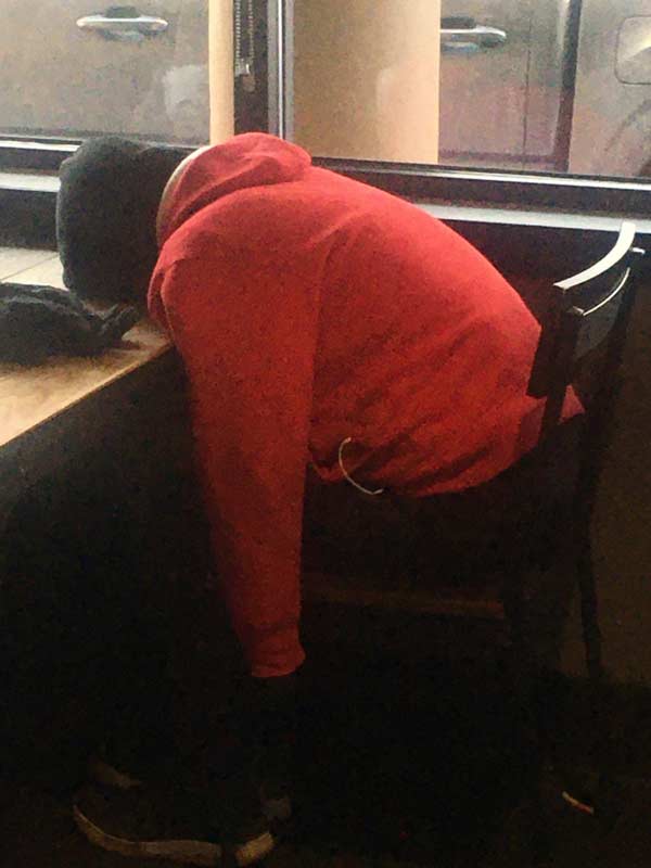 A young woman sits face-down and asleep at a table at The Alley Cat Cafe in Fort Collins, CO.