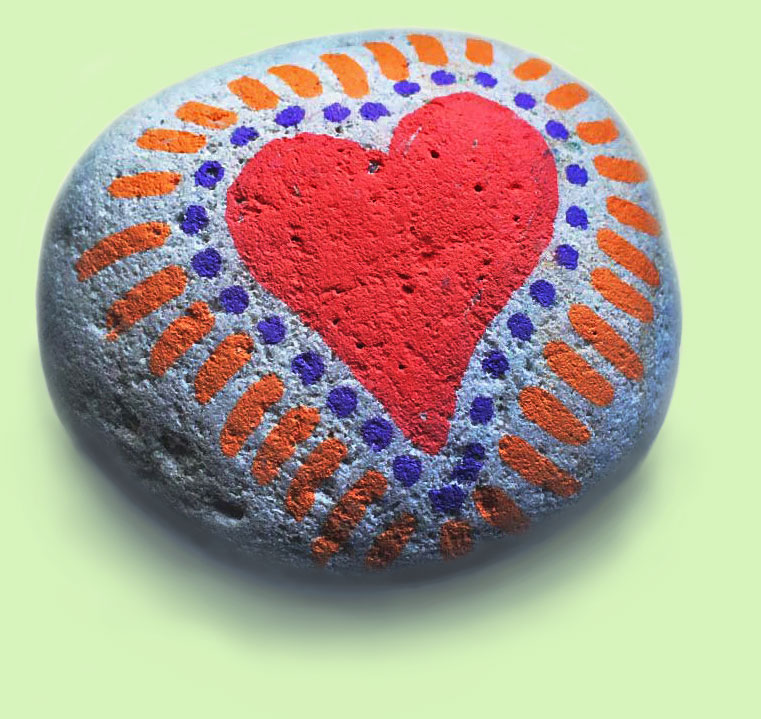 A small porous stone with a big red raditating heart painted on it.