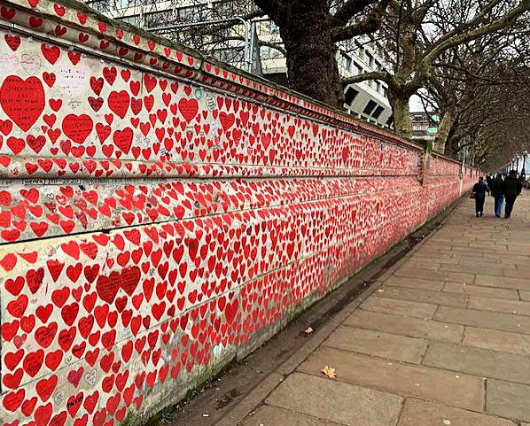Sidewalk view of the National Covid Memorial Wall in London which features over 250,000 red hearts with messages pasted on the wall, paying tribute to the men, women, and children who died of Covid-19 in the United Kingdom.