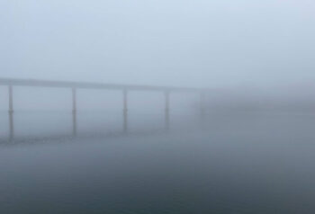 The Veterans Memorial Bridge (US Route 1) in foggy silhouette over the Passagassawakeag River in Belfast, Maine.